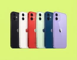 iPhone 12 mostrato in sei colorazioni — blu, nero, bianco, rosso, verde e viola — disposti in diagonale con la parte posteriore rivolta verso l’alto. Ogni telefono mette in evidenza il logo Apple centrale, la doppia fotocamera in alto a sinistra e la finitura lucida del vetro posteriore.